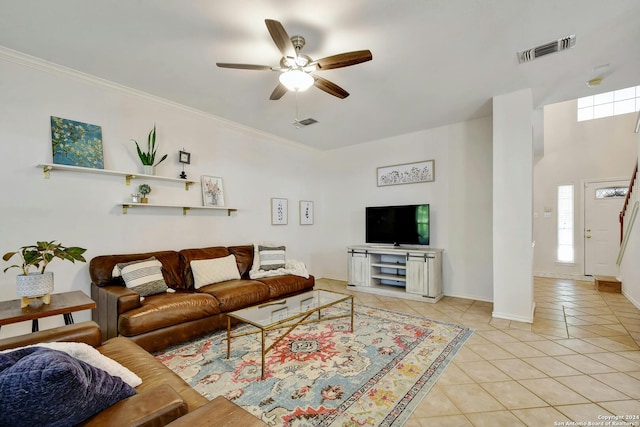 tiled living room with ceiling fan and ornamental molding