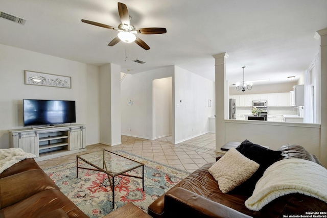 tiled living room with sink and ceiling fan with notable chandelier