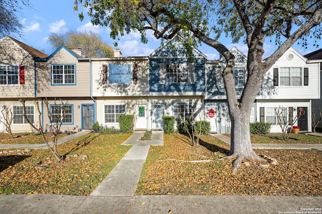 townhome / multi-family property featuring a front lawn