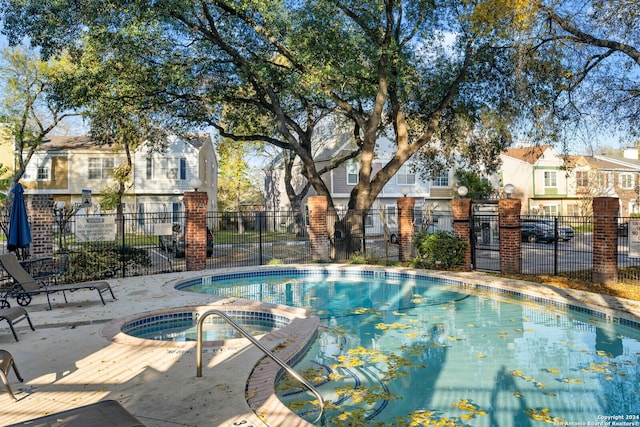 view of swimming pool with a hot tub