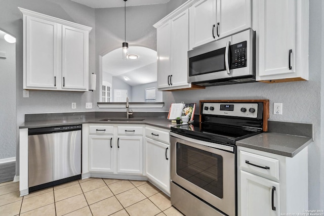 kitchen featuring sink, white cabinets, light tile patterned floors, and appliances with stainless steel finishes