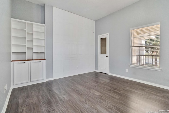 unfurnished room with dark hardwood / wood-style flooring