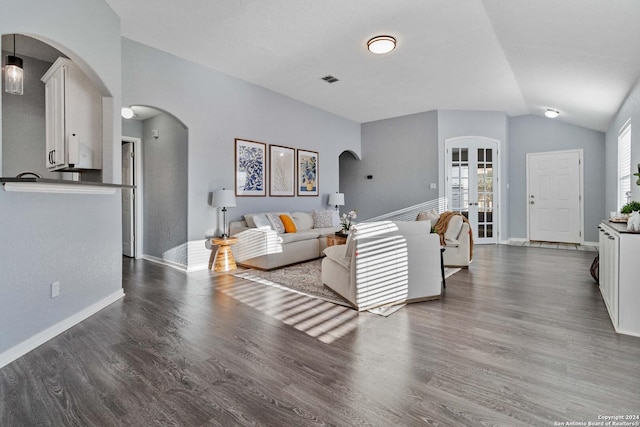 living room with french doors, dark hardwood / wood-style floors, and vaulted ceiling