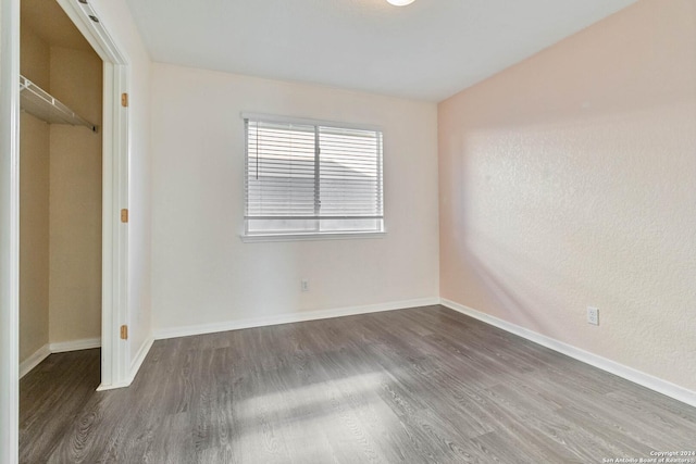 unfurnished bedroom with a closet and dark wood-type flooring