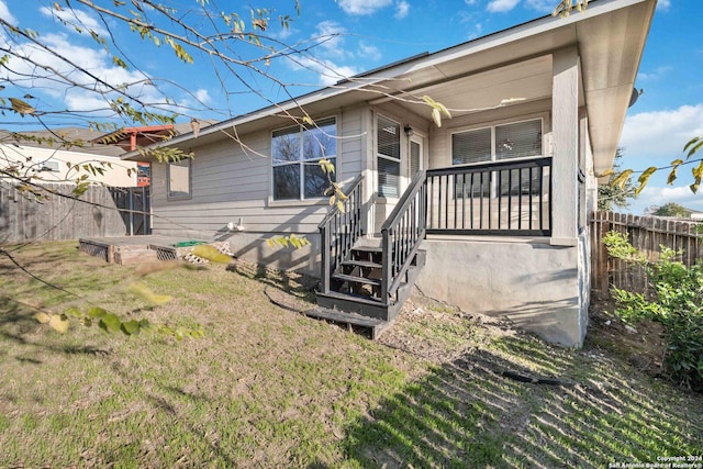 rear view of property featuring a yard and a porch