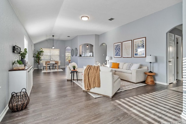 living room with dark hardwood / wood-style flooring and vaulted ceiling