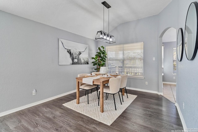 dining area with dark hardwood / wood-style flooring and vaulted ceiling