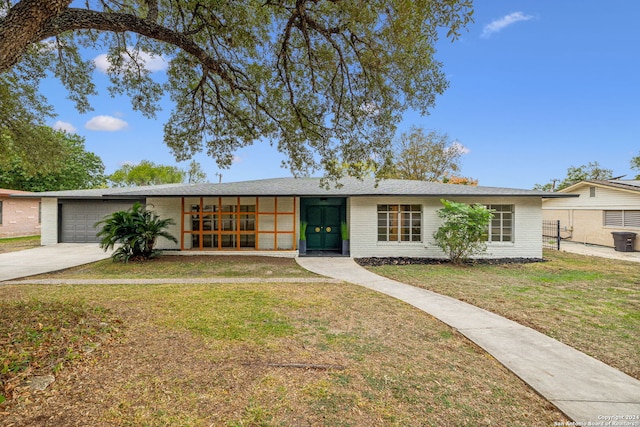 single story home featuring a front lawn and a garage