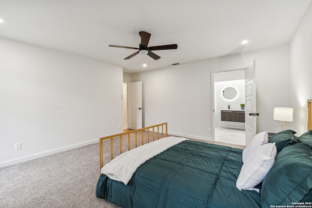 bedroom featuring ensuite bathroom, ceiling fan, and light carpet