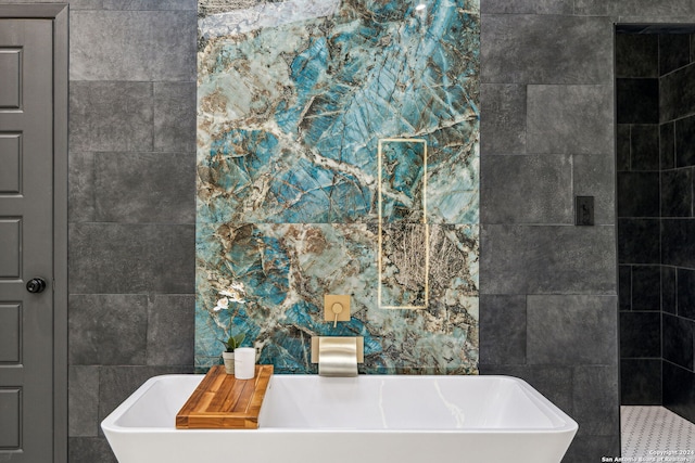 bathroom featuring a tub to relax in and tile walls