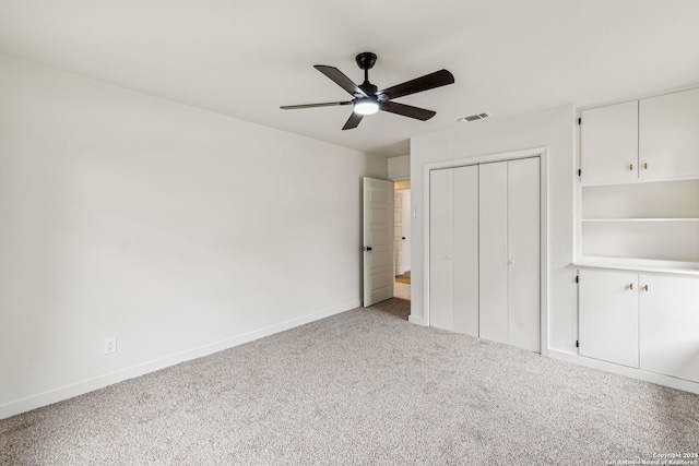 unfurnished bedroom featuring carpet floors, a closet, and ceiling fan