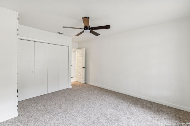 unfurnished bedroom featuring ceiling fan, light carpet, and a closet