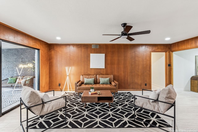 living room featuring ceiling fan and wood walls