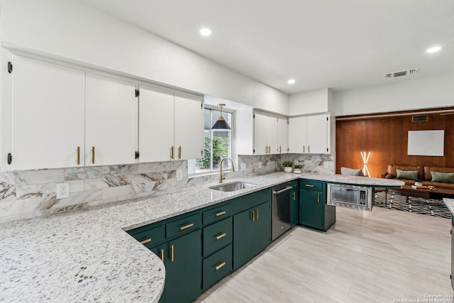 kitchen with sink, appliances with stainless steel finishes, tasteful backsplash, light stone counters, and white cabinetry