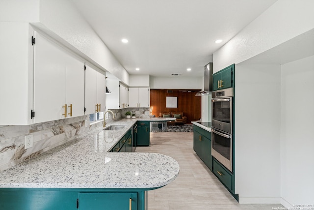 kitchen featuring white cabinetry, sink, backsplash, kitchen peninsula, and double oven