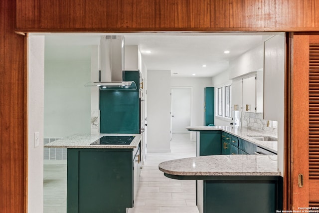 kitchen with kitchen peninsula, light stone counters, black electric cooktop, extractor fan, and white cabinets