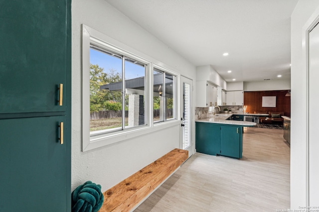 kitchen featuring white cabinetry, dishwasher, tasteful backsplash, kitchen peninsula, and a breakfast bar area