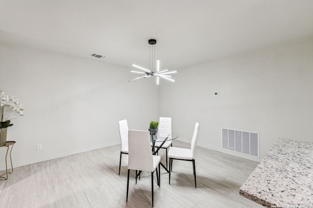 dining space featuring light hardwood / wood-style floors and a notable chandelier