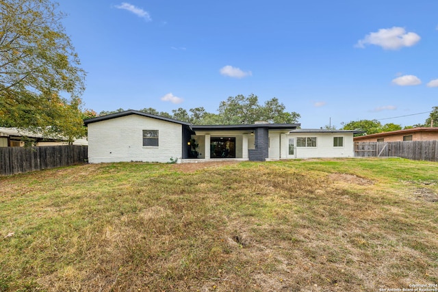 rear view of house featuring a lawn