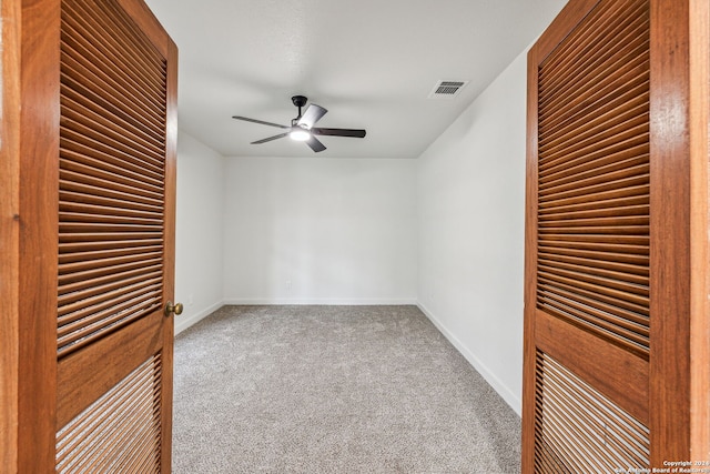 carpeted empty room featuring ceiling fan