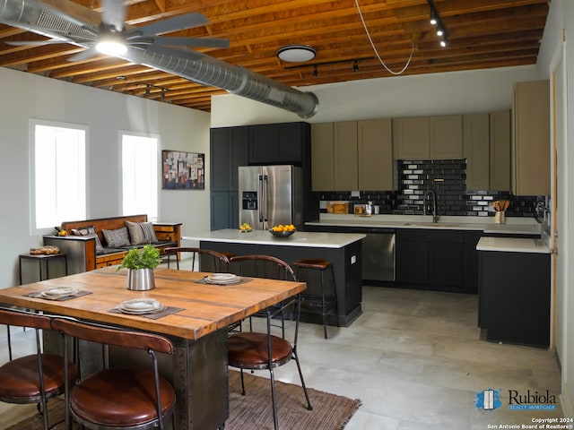 kitchen with decorative backsplash, stainless steel fridge, wood ceiling, sink, and a kitchen island