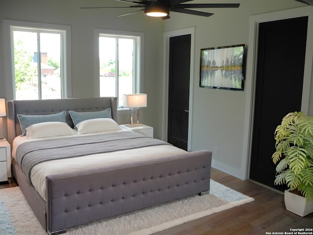 bedroom featuring multiple windows, ceiling fan, and hardwood / wood-style floors