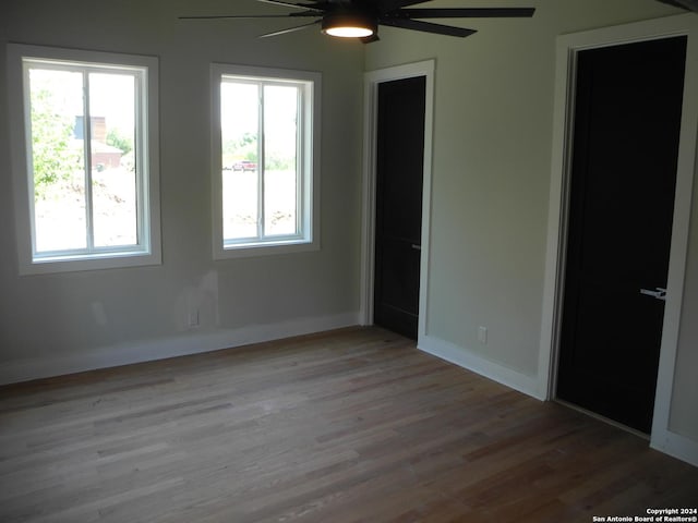 unfurnished room with ceiling fan, a healthy amount of sunlight, and light hardwood / wood-style floors