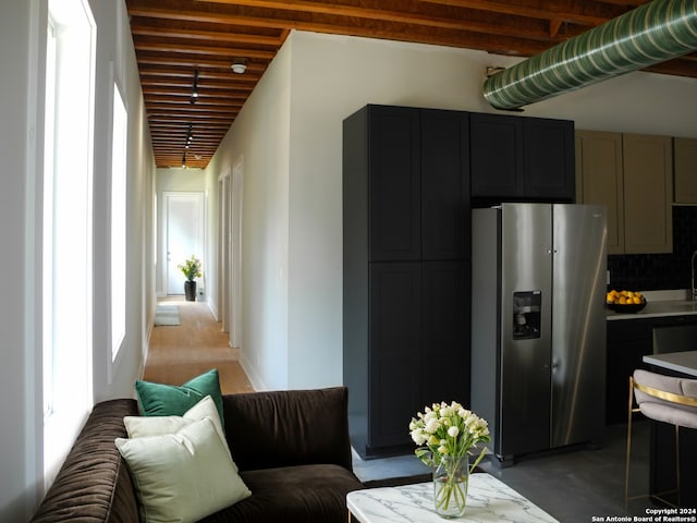 kitchen featuring gray cabinetry, stainless steel fridge with ice dispenser, and beamed ceiling