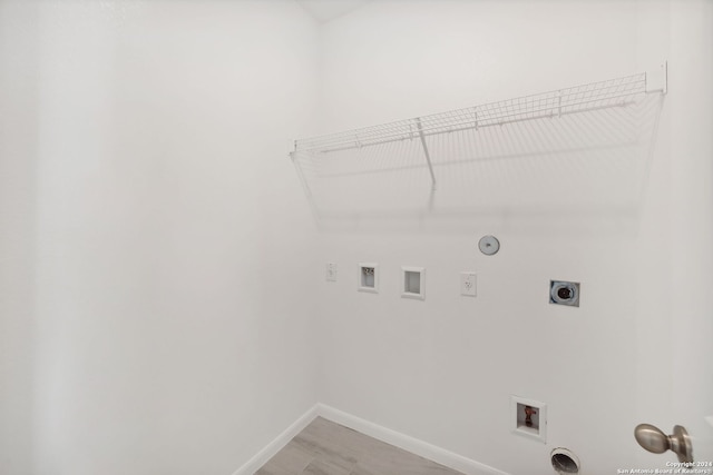 laundry area featuring hookup for a washing machine, light hardwood / wood-style floors, hookup for a gas dryer, and electric dryer hookup