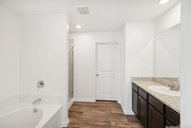 bathroom with plus walk in shower, vanity, and hardwood / wood-style flooring