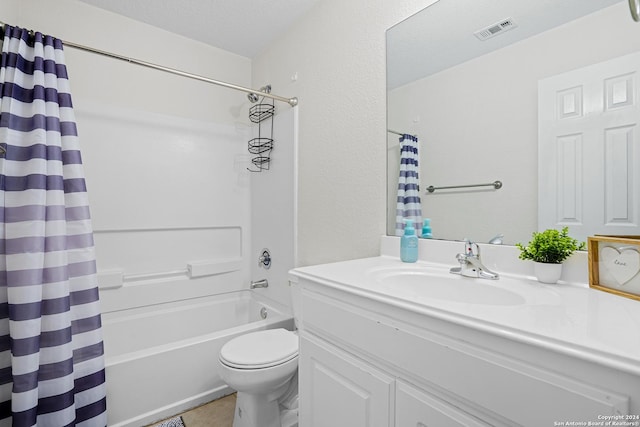 full bathroom featuring shower / bath combo with shower curtain, vanity, a textured ceiling, and toilet