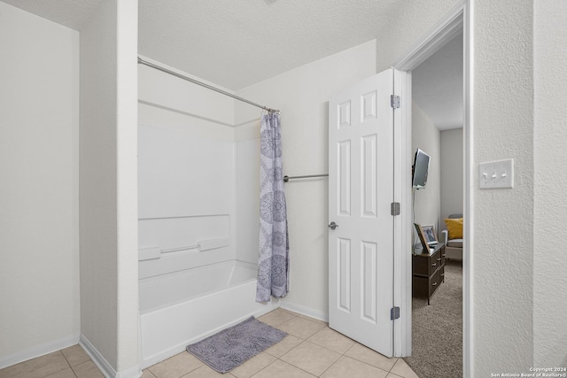 bathroom with tile patterned floors, a textured ceiling, and shower / tub combo