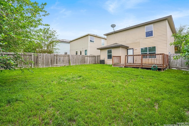 rear view of house with a deck and a lawn