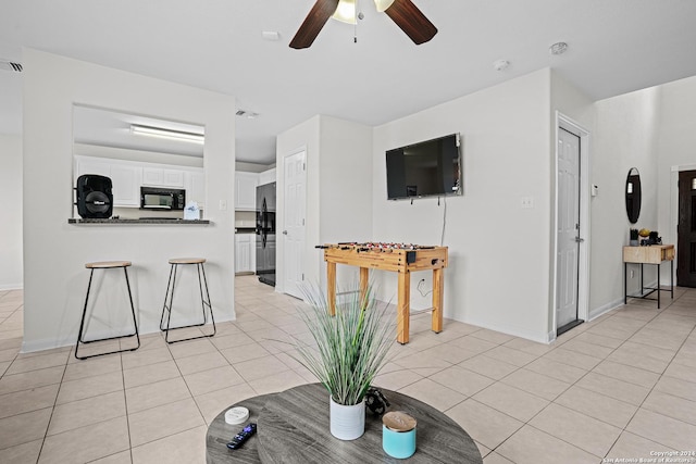 living room with ceiling fan and light tile patterned floors