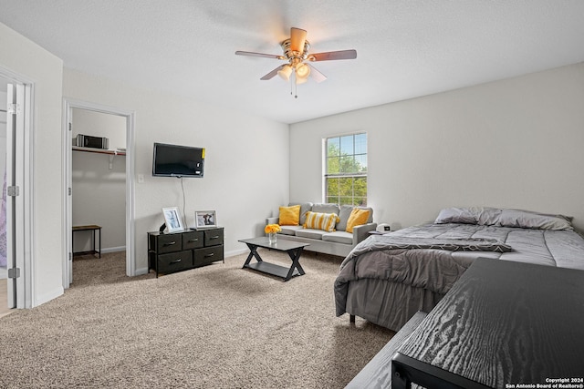 bedroom with ceiling fan, a closet, carpet, and a spacious closet