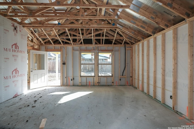 misc room featuring lofted ceiling and a garage