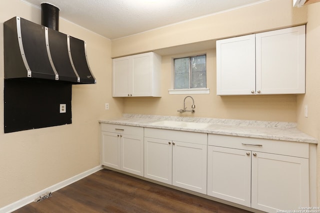 kitchen with white cabinetry, sink, light stone countertops, dark hardwood / wood-style floors, and a textured ceiling