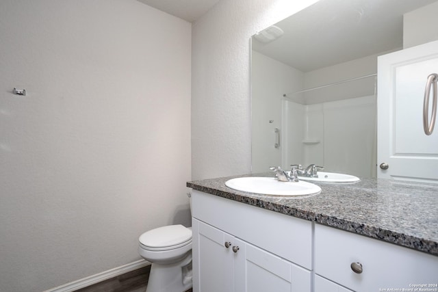 bathroom featuring walk in shower, hardwood / wood-style flooring, vanity, and toilet