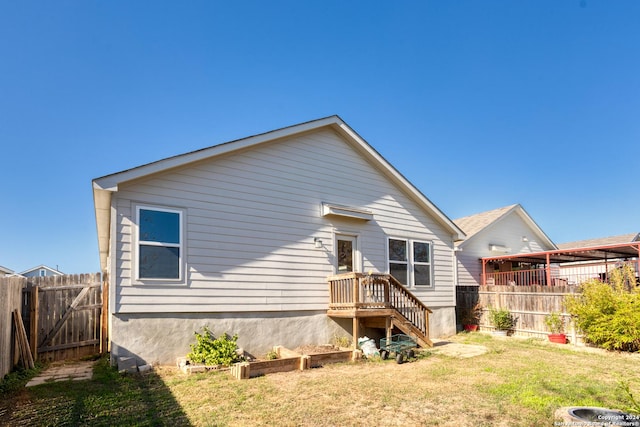 rear view of house featuring a yard