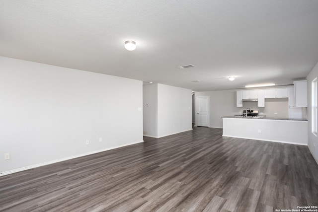 unfurnished living room with dark wood-type flooring and sink