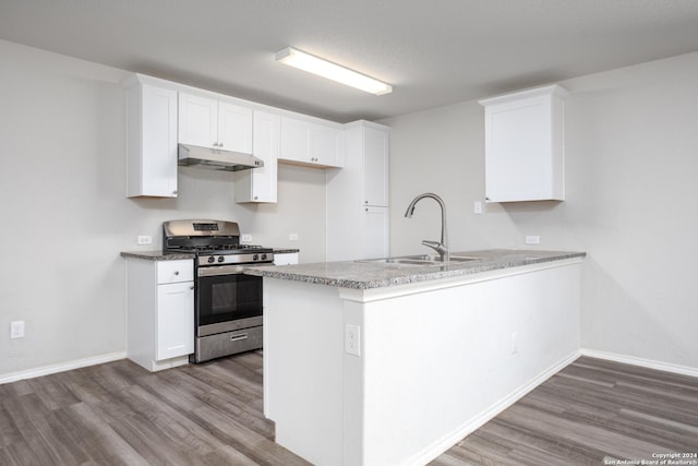 kitchen featuring white cabinets, kitchen peninsula, stainless steel gas range oven, and sink