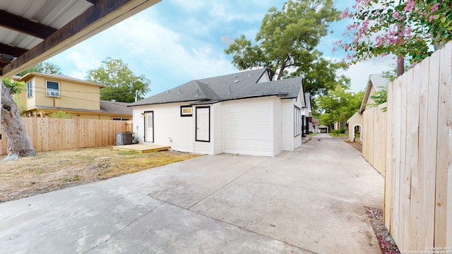 rear view of property with central AC unit and a patio area