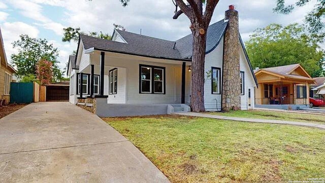 view of front of home with covered porch and a front lawn