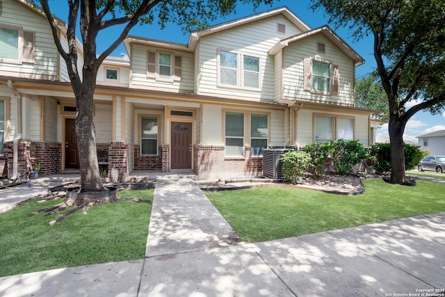 view of front of home featuring a front yard and cooling unit