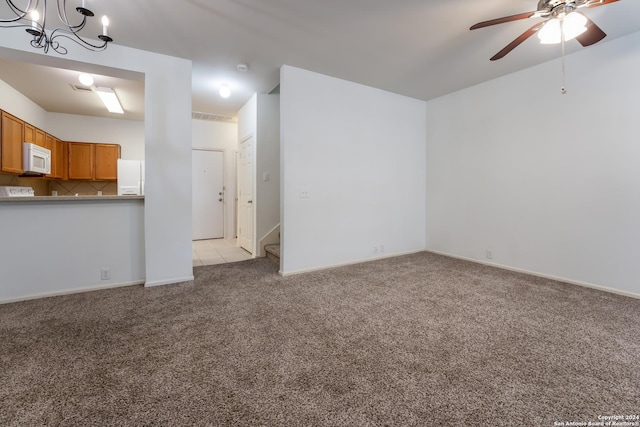 unfurnished living room with light colored carpet and ceiling fan with notable chandelier