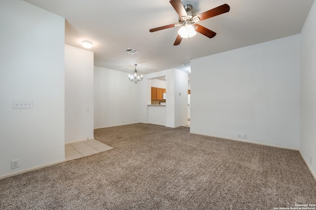 carpeted spare room with ceiling fan with notable chandelier