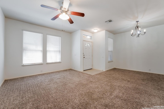 unfurnished room with ceiling fan with notable chandelier and light colored carpet