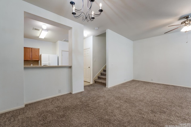 unfurnished living room with ceiling fan with notable chandelier and light colored carpet