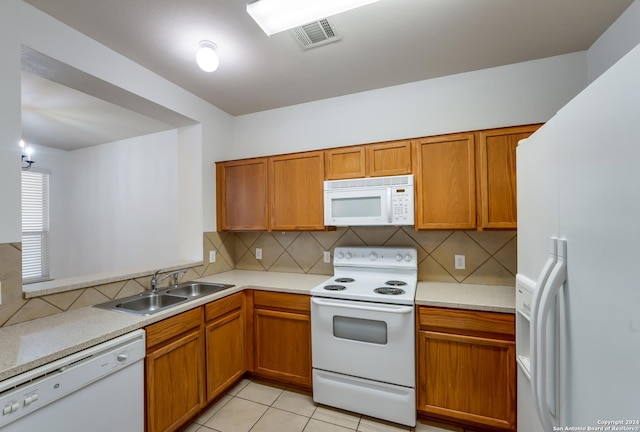 kitchen featuring tasteful backsplash, sink, light tile patterned flooring, and white appliances