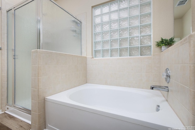 bathroom with hardwood / wood-style flooring, plenty of natural light, and independent shower and bath